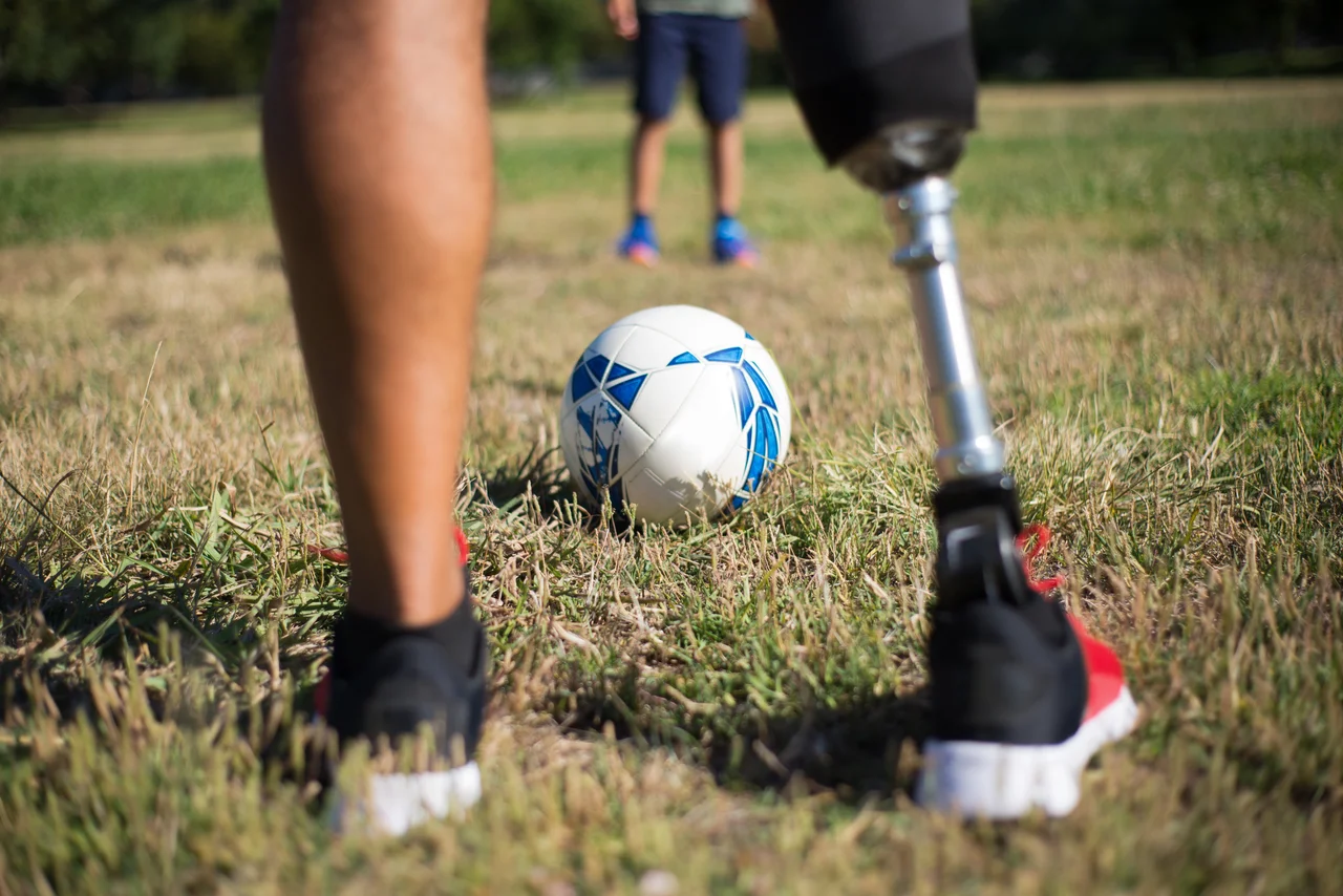 Fußball liegt zwischen einem Bein und einer Prothese